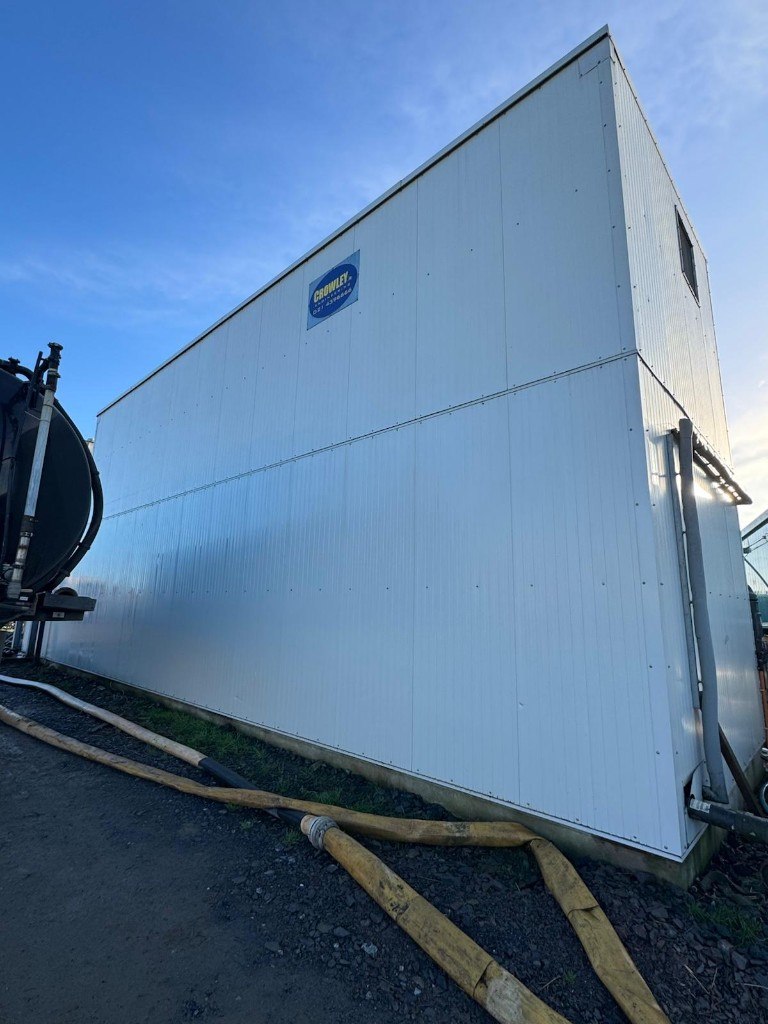 Freshly cleaned white industrial cladding against a blue sky