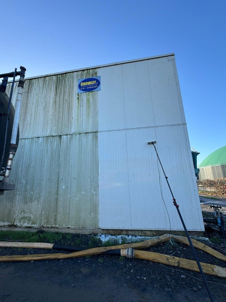 Industrial cladding half-cleaned, showing algae on the left and bright white on the right