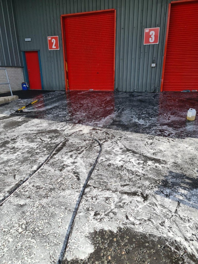 Foamed warehouse loading bays being pressure washed