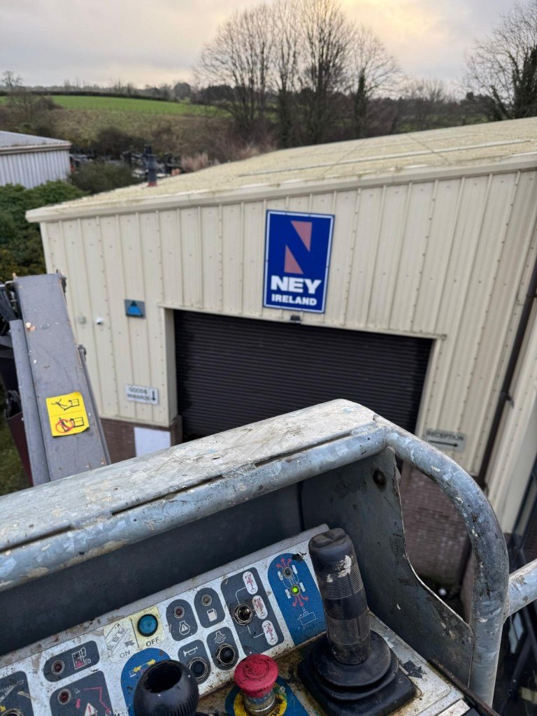 Cherry picker basket facing a warehouse elevation