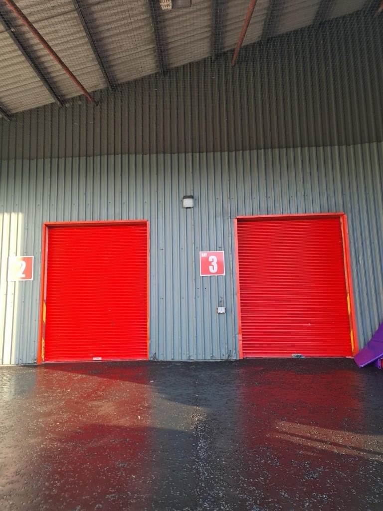 Clean wet tarmac outside warehouse bays 2 and 3